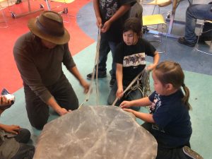 Waylon Bllackcrow makes a traditional drum with the students.